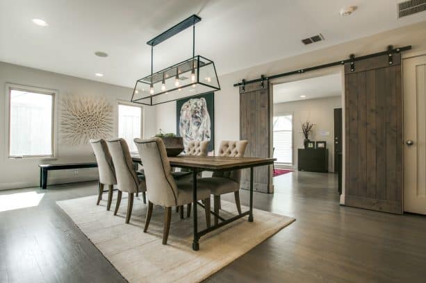 farmhouse dining room with light grey walls and stained red oak floor