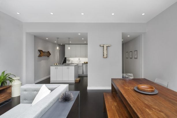 open-style living dining room with light grey wall and dark brown hardwood floor