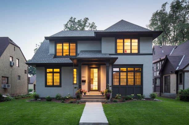 a bold traditional exterior with black trim and grey stucco