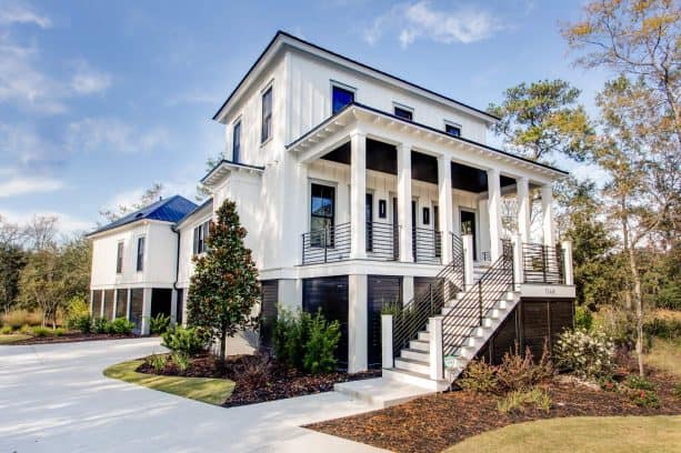 black and white contemporary exterior design with custom black wrought iron railing for the white stair