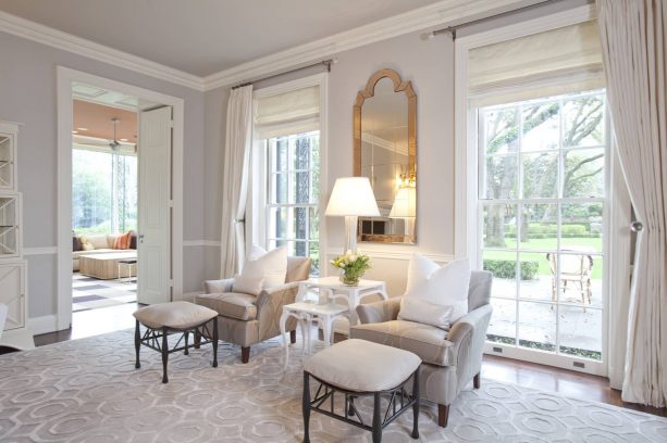 luxurious living room in pale gray wall and gold trim mirror as decoration