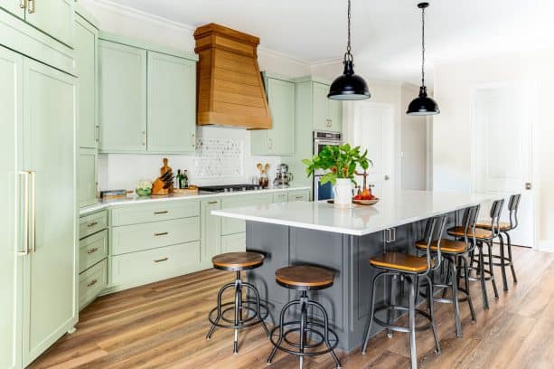 open kitchen with two islands and pretty sage green cabinets