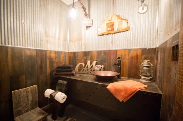 rustic man cave bathroom with a combination of cedar and steel wall