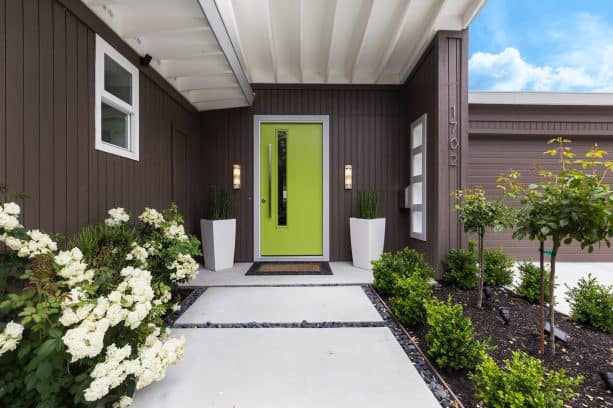 a green front door is freshly popping in the middle of brown surroundings