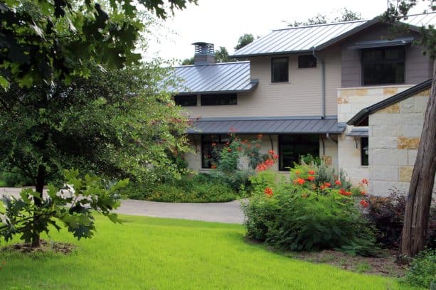 a corner lot landscaping idea involving the creation of a berm and evergreen screening plants