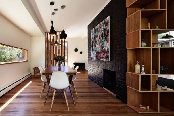 contemporary dining room with black brick fireplace and accent wall