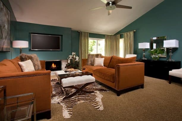 a living room with teal and rust color theme