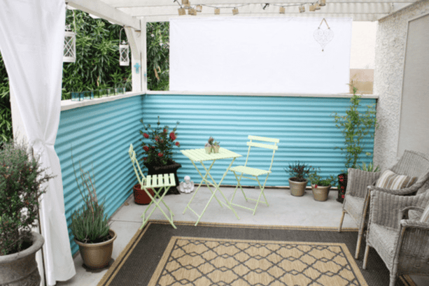 eclectic patio with turquoise corrugated metal fencing