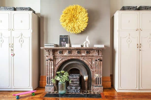 yellow juju hat on grey wall in an eclectic bedroom