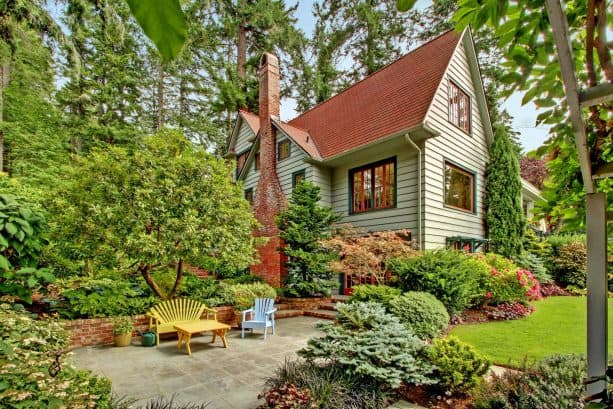 a sage green house with red brick chimney