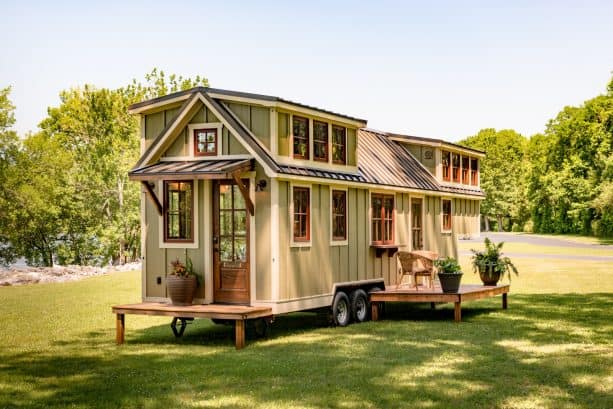 a tiny house with sage green walls, warm white trim, and wooden windows and doors