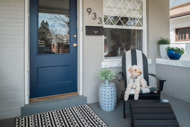 a small eclectic front porch with a pretty dark sherwin williams naval blue door