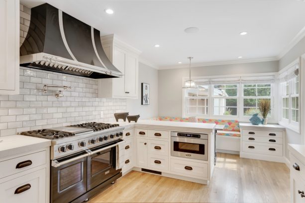 milky white cabinets with transitional u-shaped kitchen and black stainless-steel appliances