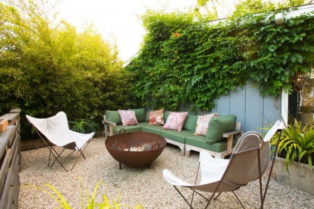 eclectic pea gravel fire pit area with a metal fire bowl in the center