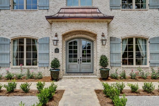 the elegant portico is made of asian style roof and bricks that match the house exterior