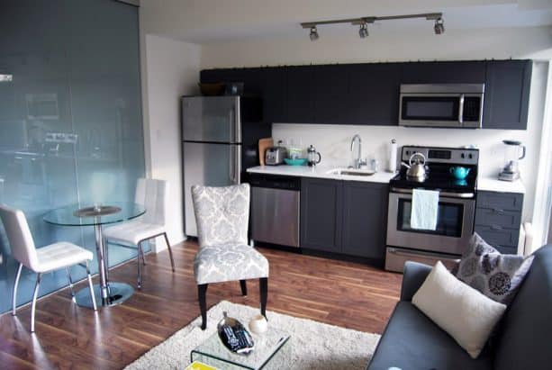 open concept kitchen with dark gray cabinets that matches the sofa in the living room