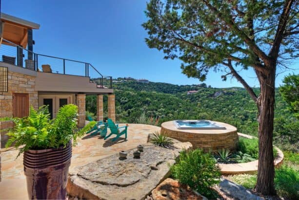 mountain style raised patio made of stone with a spa