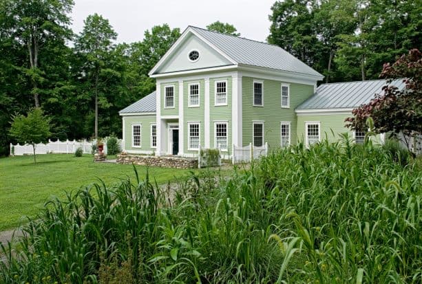 traditional exterior with a combination of englert metal roofing and cucumber salad by benjamin moore siding color