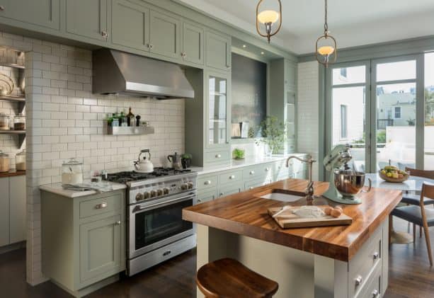 sweet victorian kitchen with sage green shaker cabinets and wood countertops