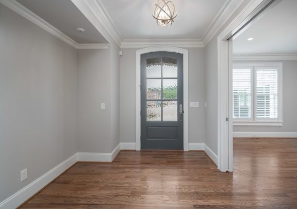 transitional entry with grey walls, hardwood floor, and darker grey door