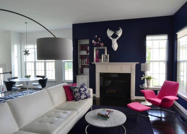 living room with navy blue wall and fuchsia pink chair