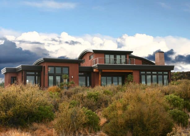 a contemporary exterior with the combination of red stucco and black trim