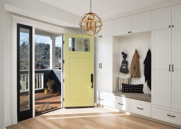 yellow pastel front door paired with beige floor in a transitional entry