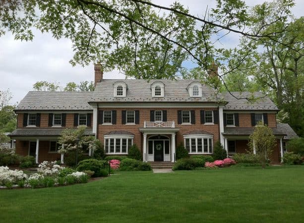 traditional red brick colonial house and black shutters