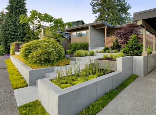 smooth surface poured concrete tiered retaining wall with a staircase in the middle