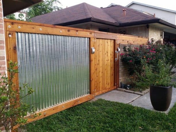 corrugated metal fence with cedar wood frame and door