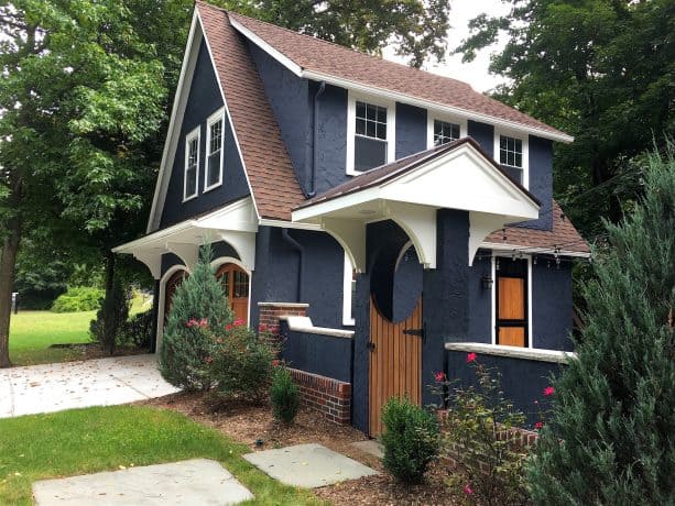 a transitional exterior with white trim and navy blue stucco