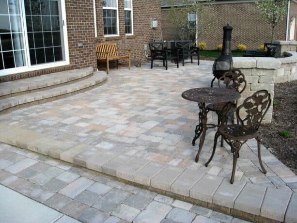 an elegant raised patio made of unilock brussels block paver with landing