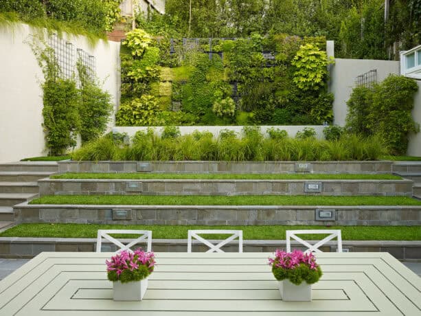 large concrete block tiered retaining wall with stairs on both sides