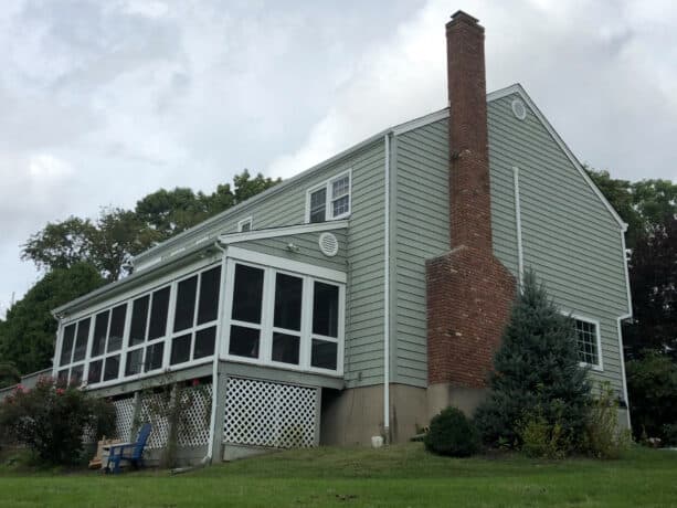 a sage green vinyl siding gracing the sides of a large house