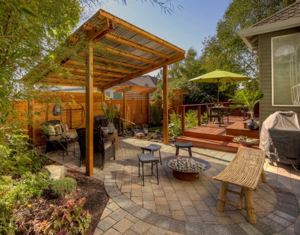 a corrugated metal roof patio cover design surrounded by a japanese garden