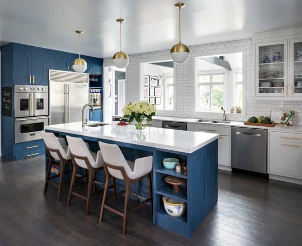 a huge floor to ceiling navy cabinet painted with benjamin moore van deusen in a kitchen with white subway tile backsplash