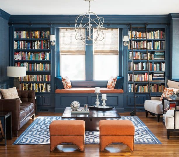 navy blue living room with orange ottomans and window seat