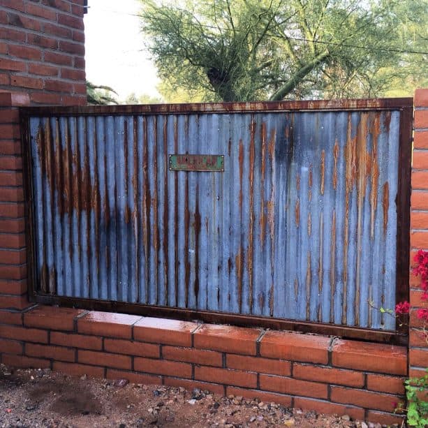 rustic corrugated metal and red brick fence