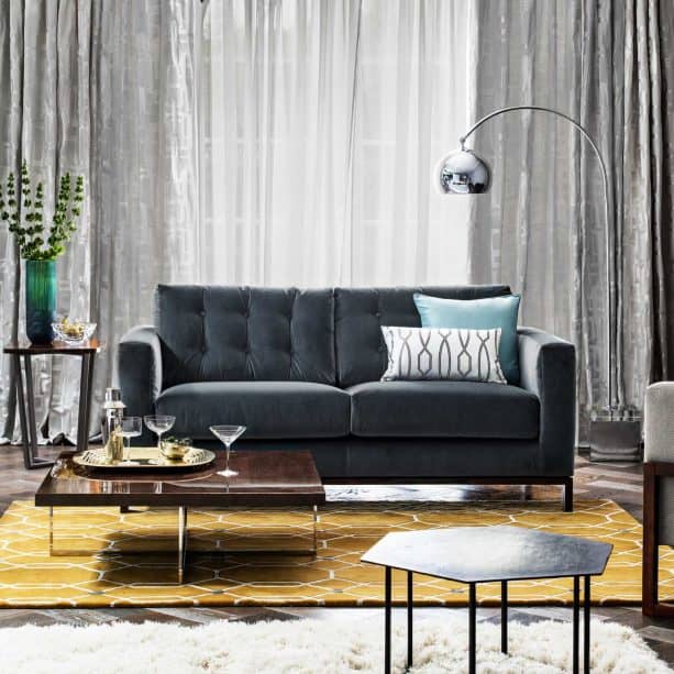 golden yellow area rug with white geometric details in a grey-dominated living room