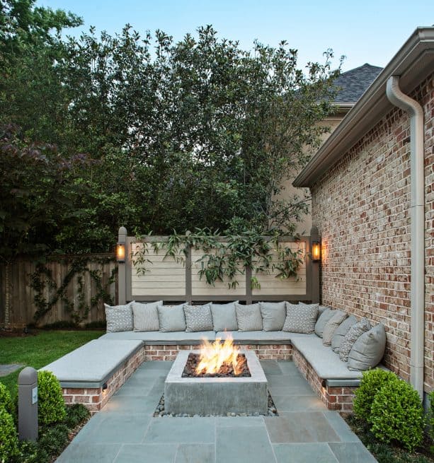 bluestone paver patio with bench seating around a square fire pit table