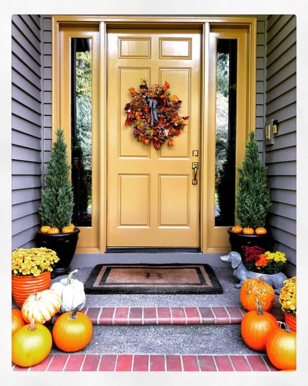 soft yellow front door with brown walls and gray floor