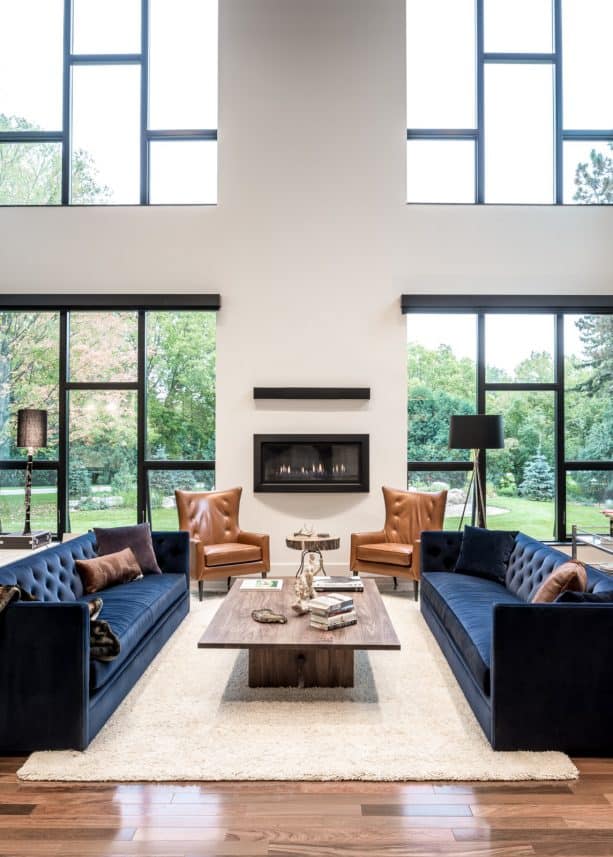 a family room with navy blue sofas and beige rug