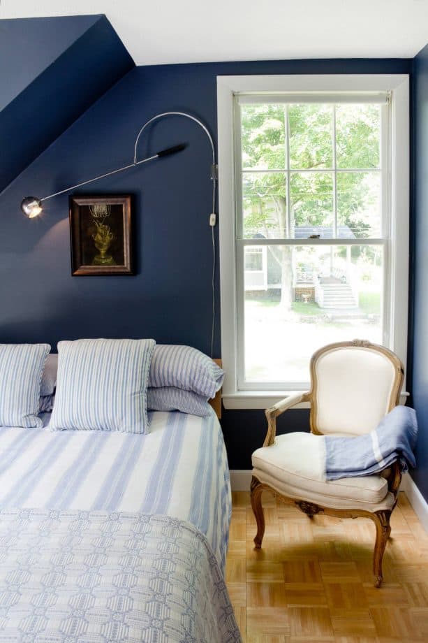 a bedroom with navy blue walls and soft blue bedding set