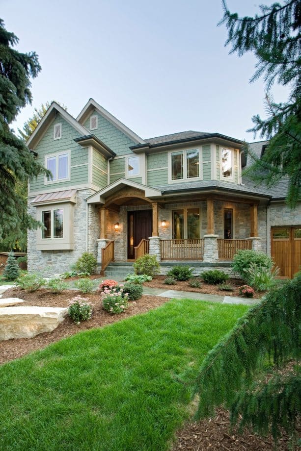 home exterior with the combination of sage green color and grey stone material