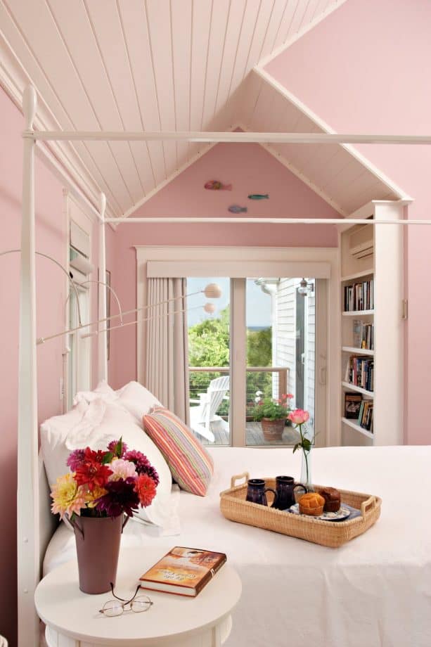 a bedroom with a white bed, pink walls and a matching sloping ceiling is such a cozy sleeping space