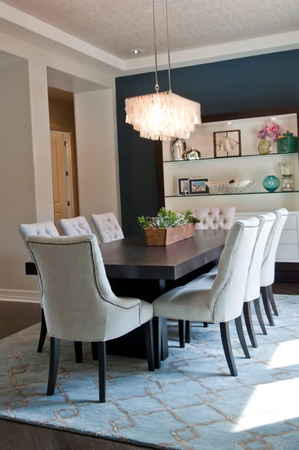 dining room with a navy blue-white accent wall and off-white chairs