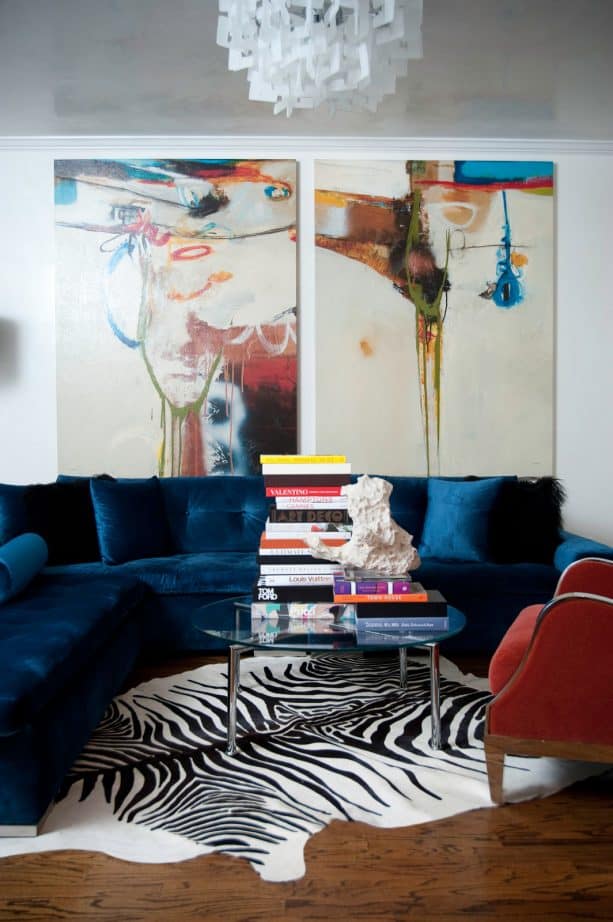 navy blue velvet sectional sofa and red chair in a contemporary living room