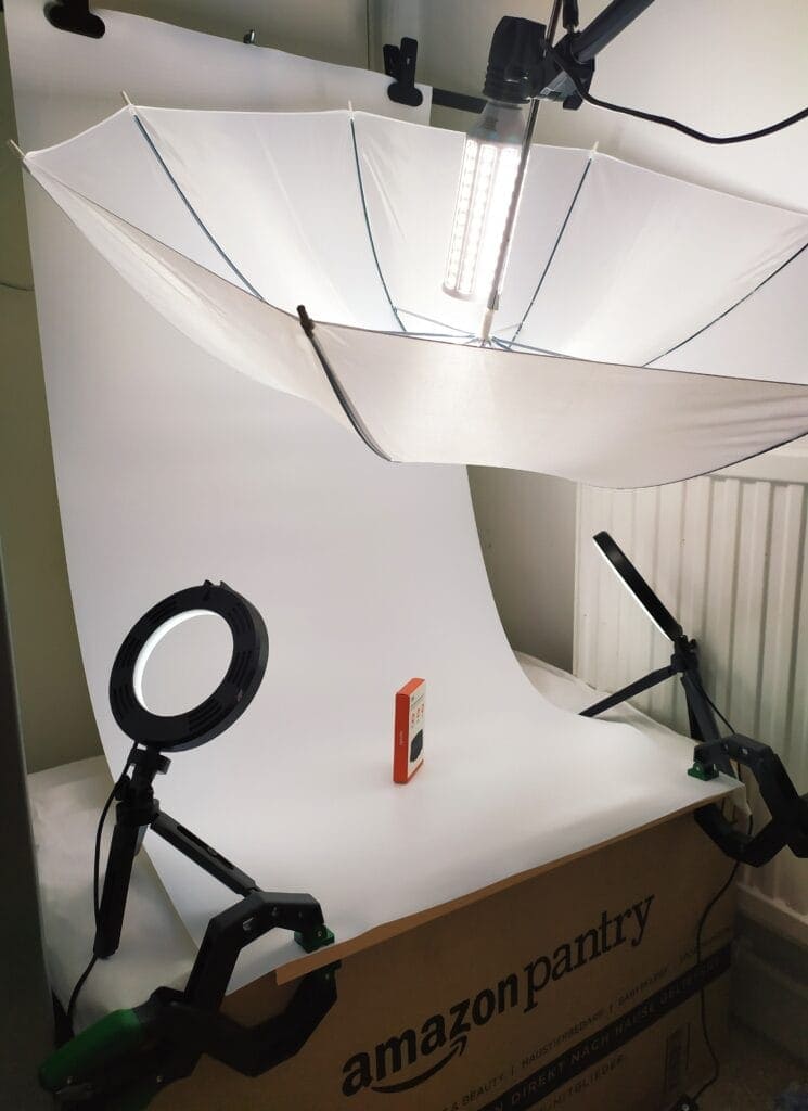 Image shows my setup. There's an umbrella with LED light over a White backdrop.