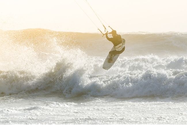 Kitesurfer jumping a wave. 