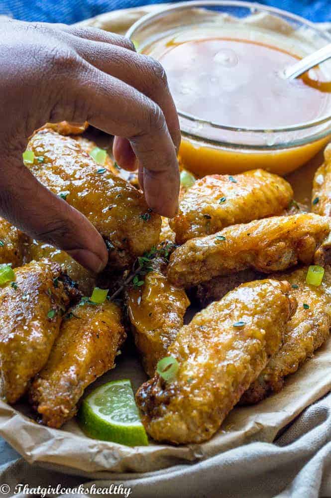 Air fryer chicken wings with hand picking up food